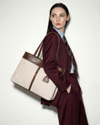 Woman in a burgundy suit holding a large mindy tote on a white background